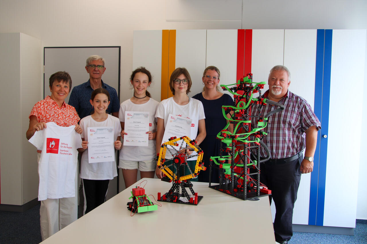 v.l.n.r.: Katrin Zauner (Geschäftsführerin, Stiftung für die Region der Sparkasse Pforzheim Calw), Thomas Petri (AG-Leiter, Jugendforschungszentrum Pforzheim-Enzkreis), Teilnehmerinnen des Girls‘ Digital Camps am Jugendforschungszentrum Pforzheim-Enzkreis, Kerstin Weipert (WFG) und Jürgen Stepper (Leiter, Jugendforschungszentrum Campus Pforzheim-Enzkreis)